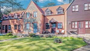 A row of brick houses with a well-maintained lawn and outdoor seating area. - 2 Bed in Cromer (oc-s1149) (Cromer)