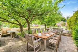An outdoor dining area with a wooden table set for six, surrounded by wooden chairs. - 6 Bed in Appledore (oc-t27531) (Appledore)