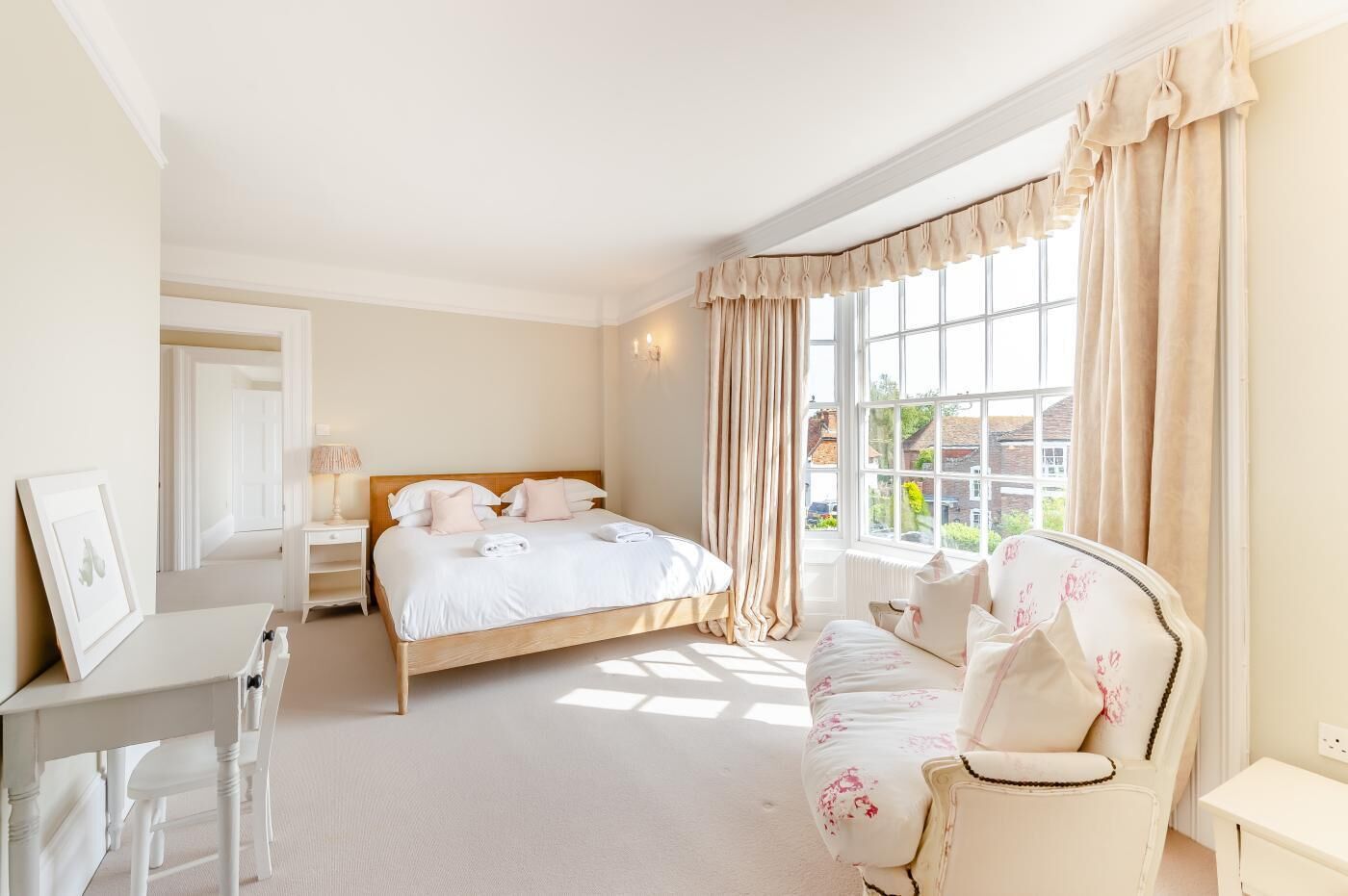 A bedroom with a bed, a bedside table, a chair, and a window with curtains.