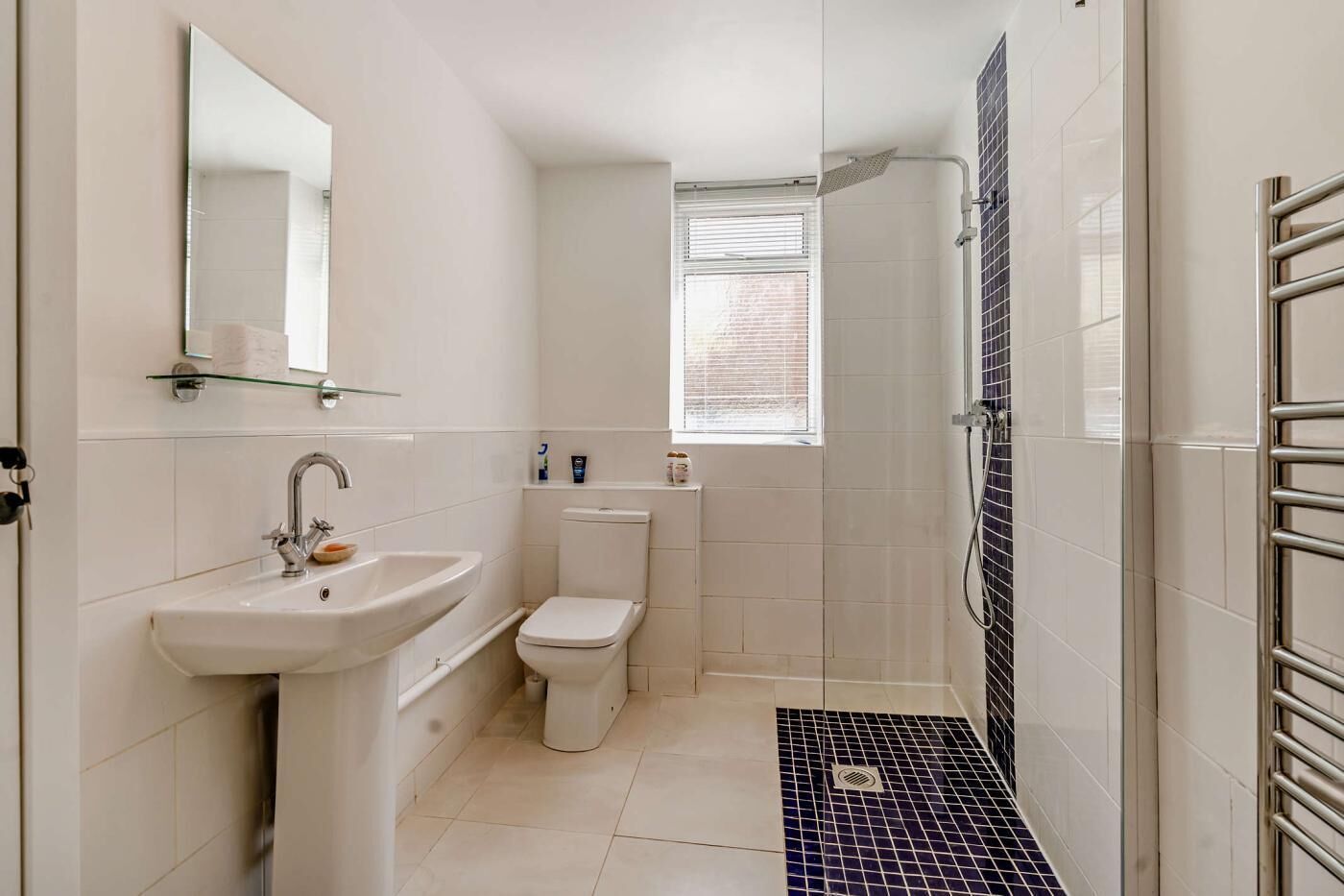 A bathroom with a sink, toilet, and shower.