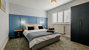 A bedroom with a bed, bedside tables, a wardrobe, and a window with blinds. - 3 Bed in Ruswarp (oc-wa264) (Ruswarp)
