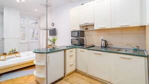 Een moderne keuken met witte kastjes, een groen aanrechtblad en een ingebouwde oven.