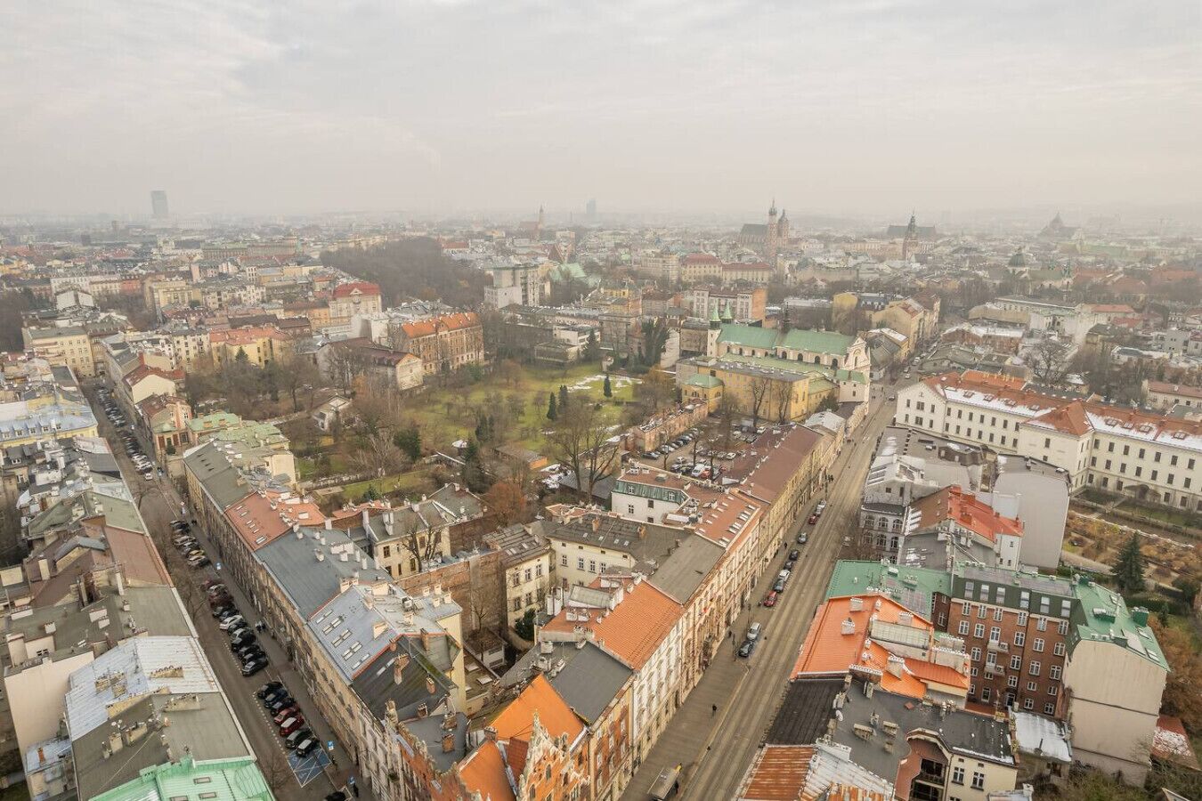 Luchtbeeld van een stadsgezicht met historische gebouwen, een opvallende kerk en een groot open plein.