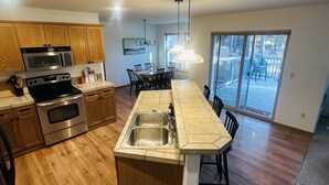 Una cocina moderna con armarios de madera, electrodomésticos de acero inoxidable y una isla grande con un lavabo.