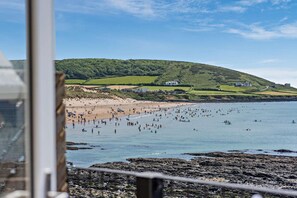 A coastal view with a beach, rocky shoreline, and a hill with buildings. - 2 Bed in Croyde (oc-r27591) (Croyde)