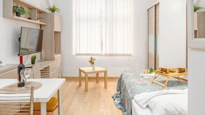 Un dormitorio moderno con cama, mesita de noche y escritorio con silla.