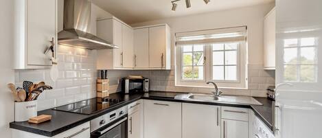 Oppvaskmaskin, høy barnestol og kjøkkenutstyr