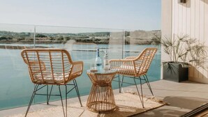 A balcony with wicker chairs and a glass table overlooking a body of water. - 3 Bed in Hayle (oc-t27597) (Hayle)