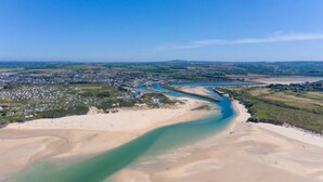 An aerial view of a coastal area with a river, sandy beaches, and a residential area. - 3 Bed in Hayle (oc-t27597) (Hayle)