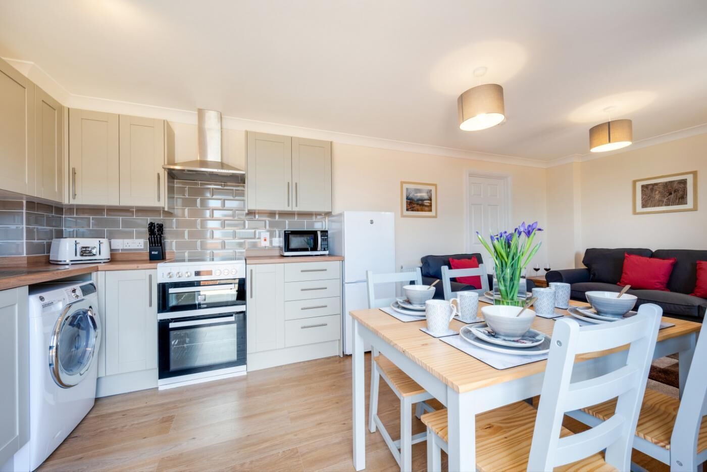 Een magnetron, een oven, een kinderstoel, kookgerei, borden en bestek