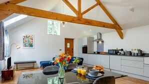 A modern kitchen with white cabinets, a dining table with chairs, and a bench. - 1 Bed in Dunston (oc-h27629) (Stoke Holy Cross)