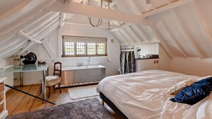 Un dormitorio con una cama grande, un escritorio y una ventana.
