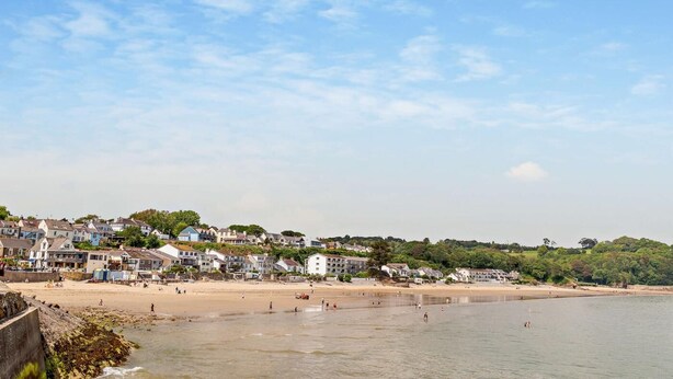 A coastal town with a sandy beach, houses, and a clear sky. - 2 Bed in Saundersfoot (oc-s27727) (Saundersfoot)