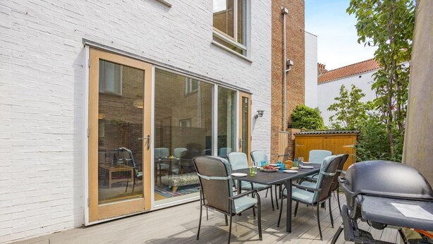 An outdoor patio with a table and chairs, a barbecue grill, and a sliding glass door leading to a covered area. - 2 Bed in Southwold (oc-ftw2) (Southwold)