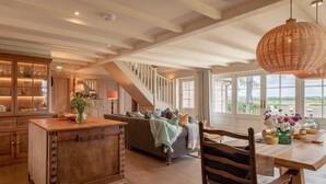 A spacious kitchen with a wooden island, a dining area with a table and chairs, and a staircase leading to an upper level. - 3 Bed in Wittersham (oc-m27683) (Wittersham)
