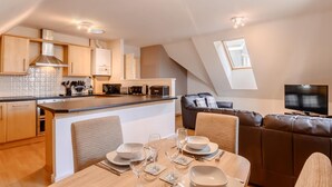 Een modern appartement met keuken, eethoek en woonkamer.