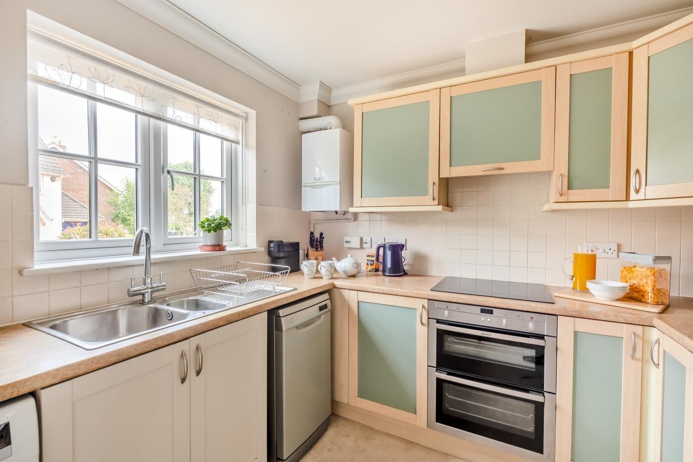 Une cuisine équipée d’un évier, d’un lave-vaisselle, d’une cuisinière et de placards.