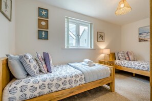 A bedroom with two single beds, a window, and wall decorations. - 2 Bed in St. Issey (oc-o27778) (Saint Issey)