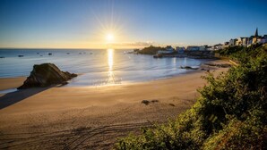 A beach with a clear view of the sea and a rocky outcrop. - 1 Bed in Saundersfoot (oc-pw927a) (Saundersfoot)