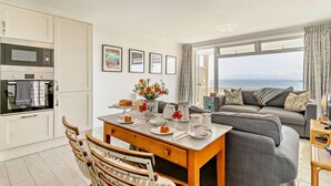 Une cuisine moderne avec un coin repas, un canapé et une vue sur la mer.