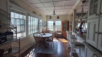 A dining area with a table, chairs, and a window overlooking a garden.