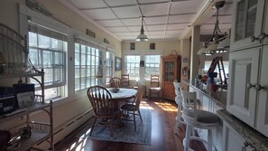 Comedor con una mesa, sillas y ventana con vista a un jardín.