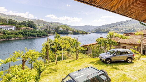 A river, a car, and a building with a roof.