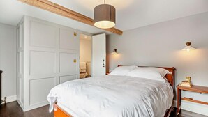 Ein Schlafzimmer mit einem großen Bett, einem Holz-Kopfteil und einer Deckenleuchte.