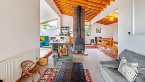 A spacious living area with a high ceiling, a fireplace, and a cozy seating arrangement. - 5 Bed in Rye (oc-o27820) (Rye)