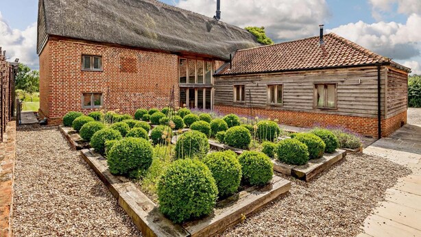 A brick building with a thatched roof and a wooden structure with a tiled roof. - 5 Bed in Ellough (oc-d8656) (Ellough)