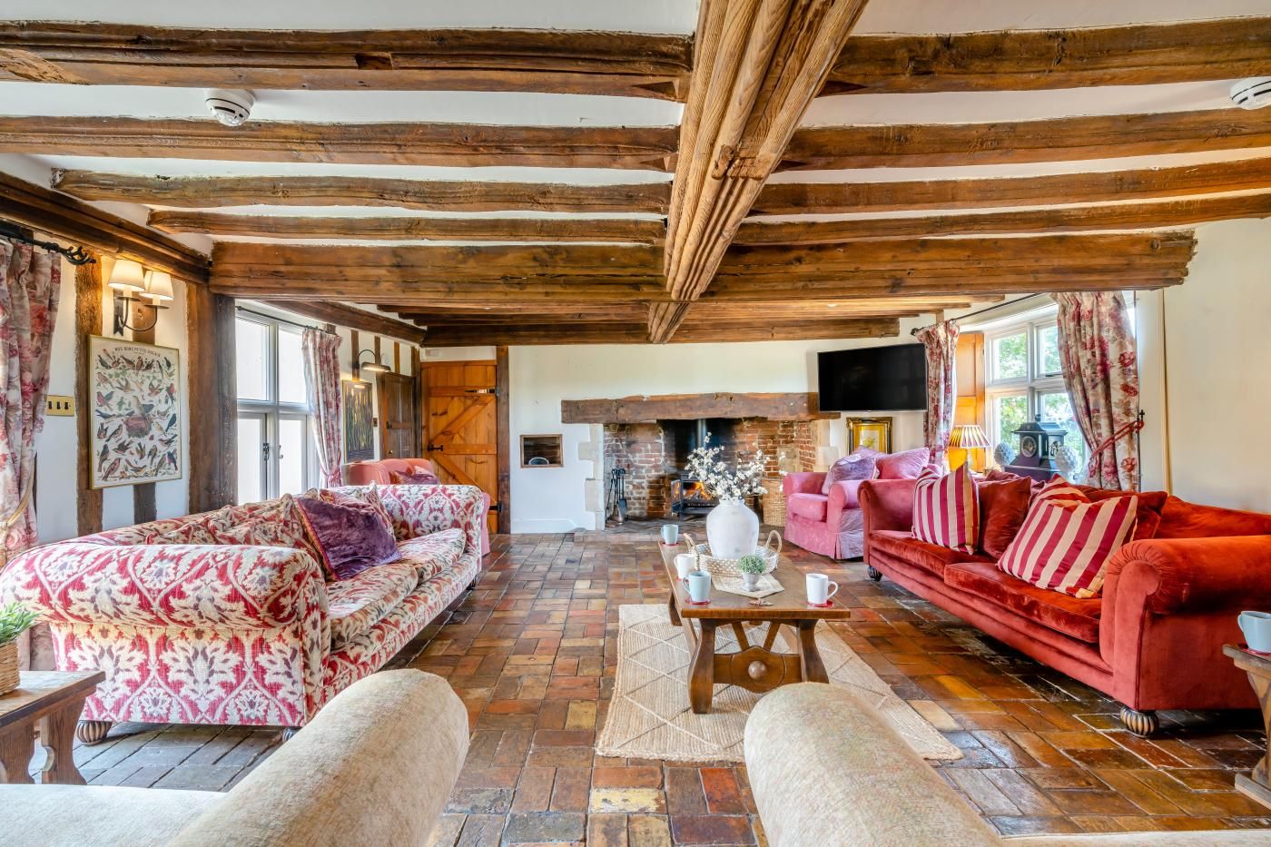 A cozy living room with a fireplace, two sofas, and a television.