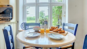 Ein Esstisch mit Tellern, Croissants und Orangensaftgläsern.