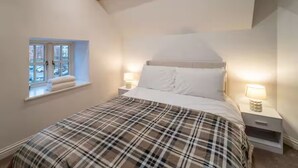 Une chambre à coucher avec un lit, une fenêtre et deux tables de chevet avec des lampes.