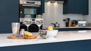 Eine moderne Küche mit dunklen Schränken, einer weißen Arbeitsplatte und einem Edelstahlbackofen.