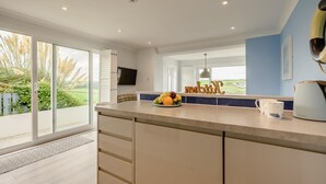 Una cocina moderna con una isla grande, un televisor de pantalla plana y vistas al exterior.