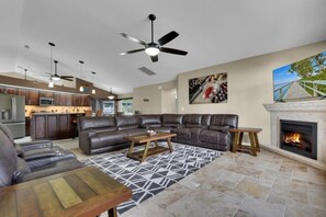 Ein modernes Wohnzimmer mit Ecksofa, Couchtisch und Kamin.