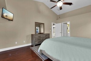 A bedroom with a bed, a dresser, a ceiling fan, and a television. - Tuscan Treasure Bike, Kayaks, Peddleboat Included (Cape Coral)