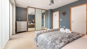 A bedroom with a bed, a dresser, a mirror, and a door. - 2 Bed in Southwold (oc-t27861) (Southwold)