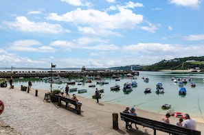 A harbor with boats, a stone pier, and people walking along the shore. - 2 Bed in St Ives (oc-wrenc) (St Ives)