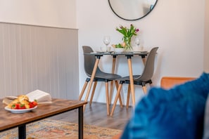 Un comedor con una mesa, sillas y un florero.