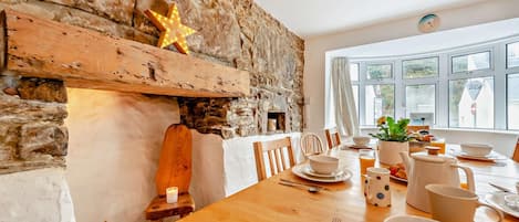 A dining area with a stone wall, wooden furniture, and a star decoration.