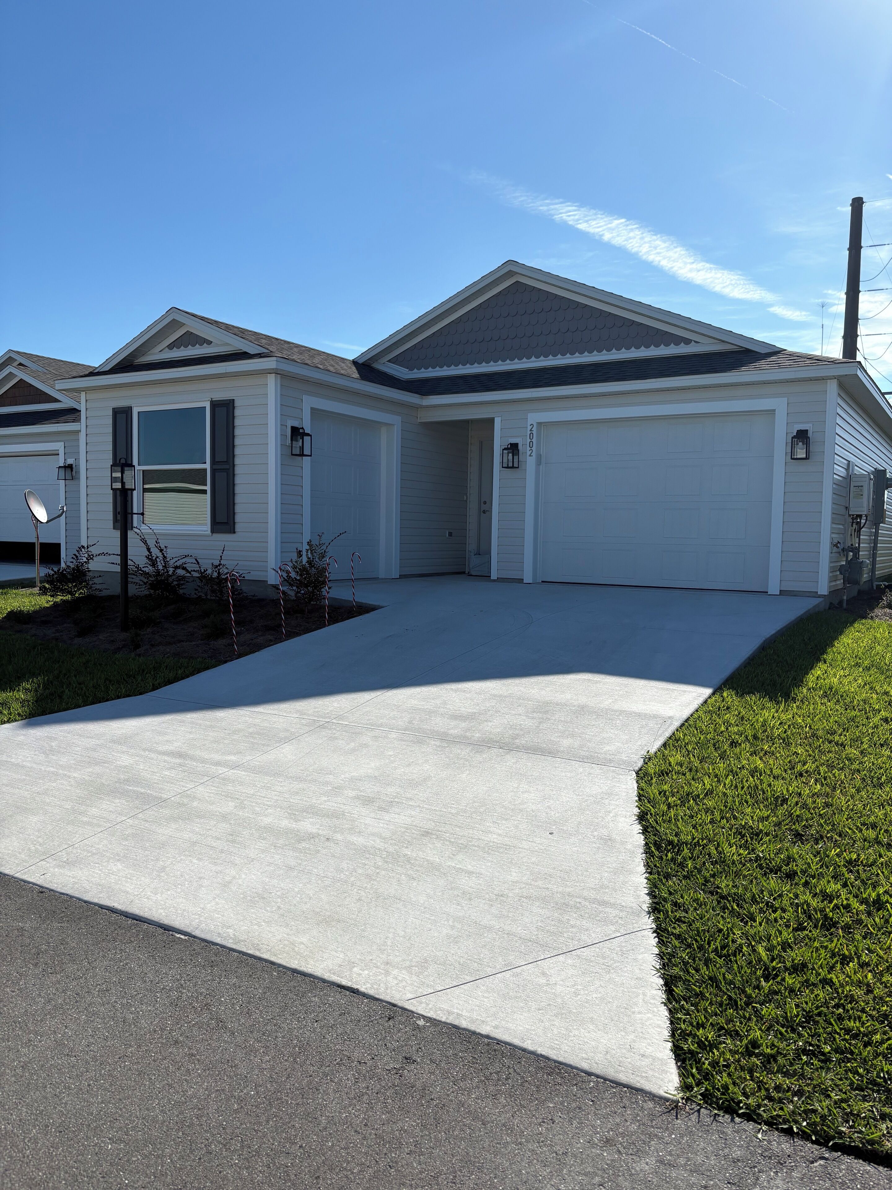 A single-story house with a garage, a driveway, and a well-maintained lawn.
