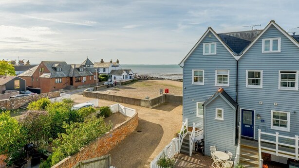 Une zone résidentielle côtière avec des maisons, une plage et un ciel dégagé.