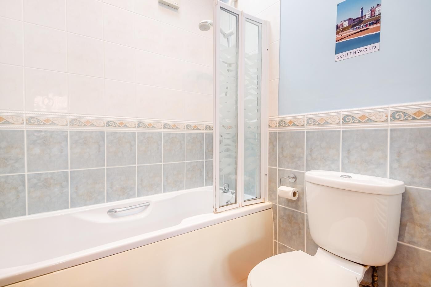A bathroom with a bathtub, toilet, and a shower enclosure.
