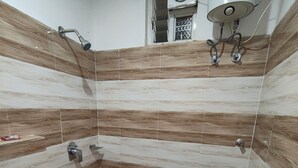 A small bathroom with a toilet, a shower, and a sink. - HOTEL ARDENT (Ranchi)