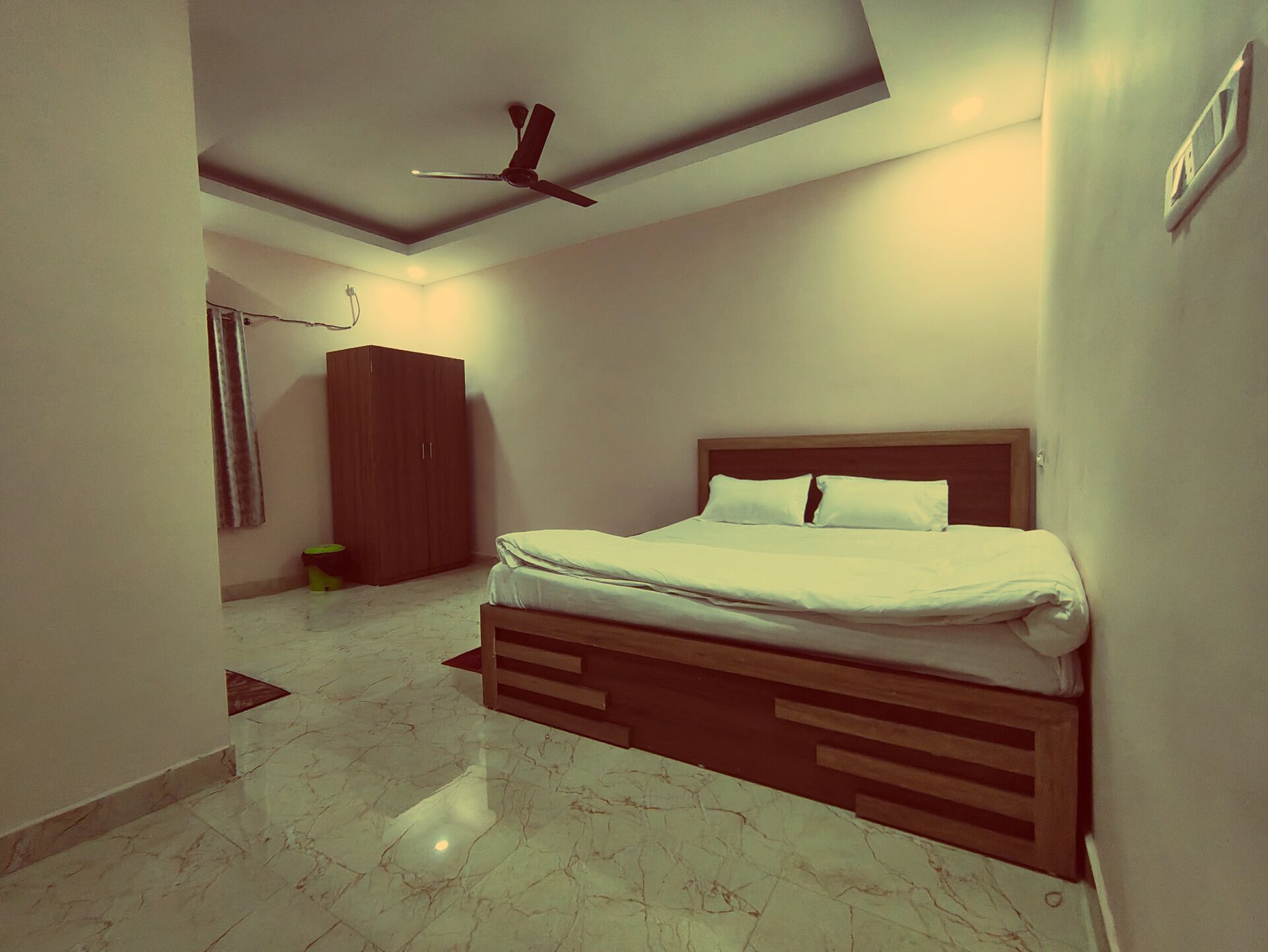 Un dormitorio con cama, ventilador de techo, armario y baño con cortina de ducha.