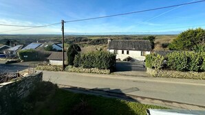 A rural road with a stone wall and a house with a tiled roof. - 3 Bed in St. Breward (oc-g28144) (Saint Breward)