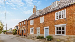 A row of red brick houses with white window frames and a clear blue sky. - 3 Bed in Southwold (oc-r11173) (Southwold)