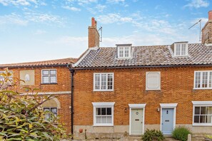 A traditional brick building with a tiled roof, multiple windows, and a sign indicating 'ROSEMARY COTTAGES'. - 3 Bed in Southwold (oc-r11173) (Southwold)