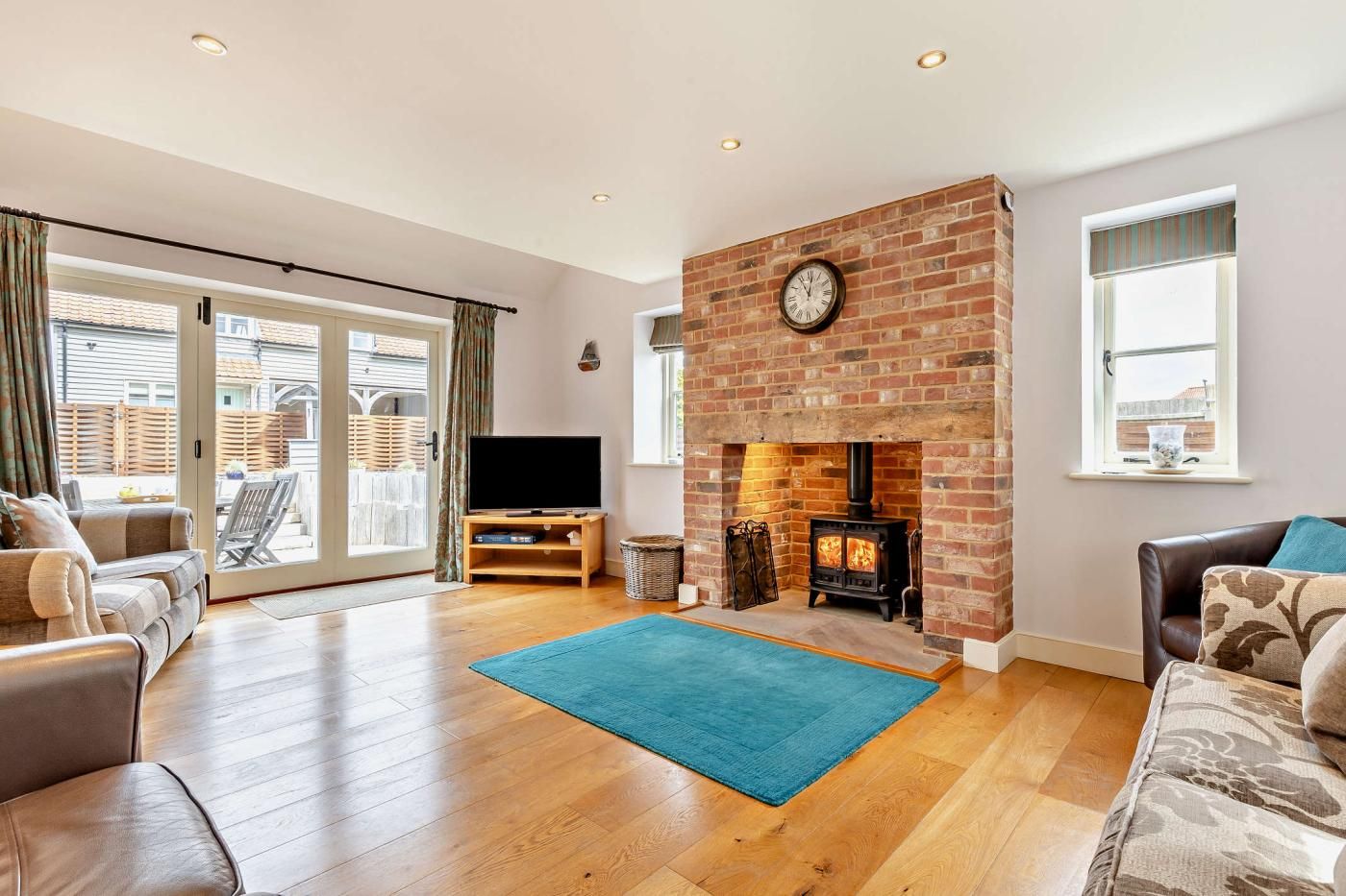 A spacious living room with a fireplace, a television, and a large window.